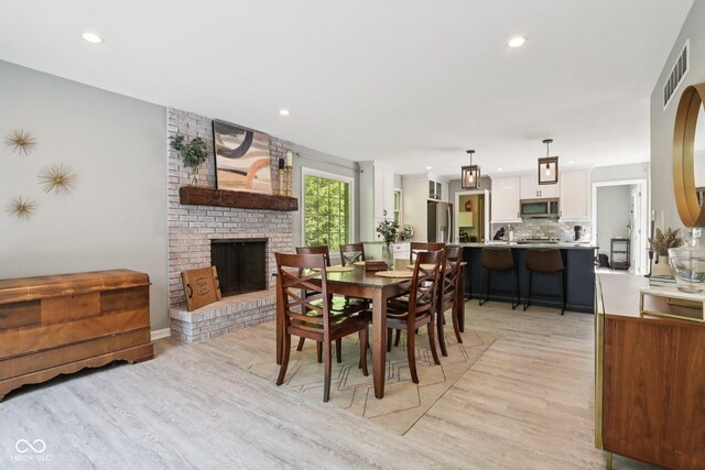 7029 Kingswood Cir, Indianapolis, IN 46256 - dining area featuring light wood-style flooring, recessed lighting, and a brick fireplace