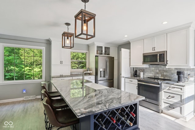 7029 Kingswood Cir, Indianapolis, IN 46256 - kitchen featuring appliances with stainless steel finishes, backsplash, white cabinetry, light wood finished floors, and recessed lighting