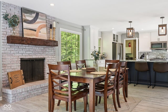 7029 Kingswood Cir, Indianapolis, IN 46256 - dining room featuring light wood-type flooring, a fireplace, and recessed lighting