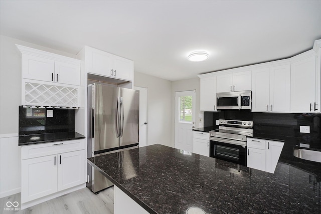 91 N Raceway Rd, Indianapolis, IN 46234 - kitchen with stainless steel appliances, white cabinets, dark stone counters, and a peninsula