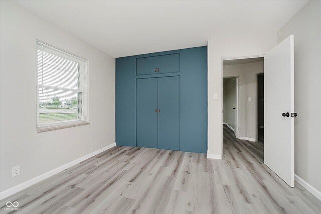 91 N Raceway Rd, Indianapolis, IN 46234 - unfurnished bedroom featuring light wood-type flooring and a closet
