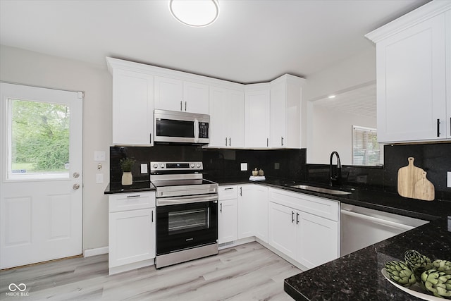91 N Raceway Rd, Indianapolis, IN 46234 - kitchen featuring appliances with stainless steel finishes, decorative backsplash, white cabinets, and light wood-type flooring