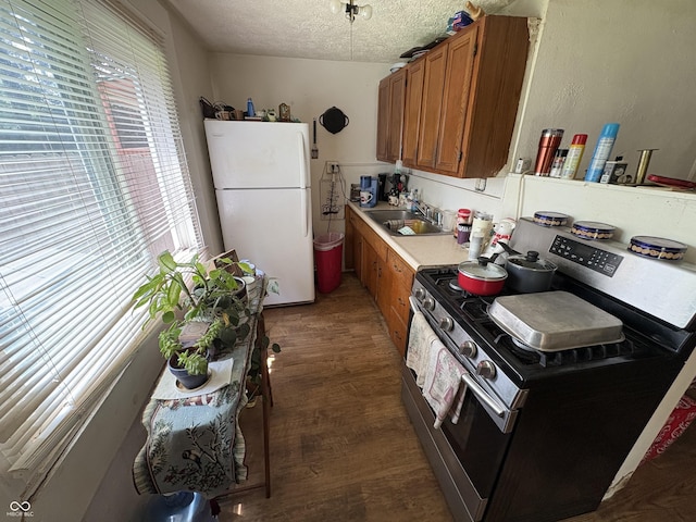 1809 E 13th St, Muncie, IN 47302 - kitchen with stainless steel range with electric cooktop, freestanding refrigerator, brown cabinetry, a textured ceiling, and light countertops