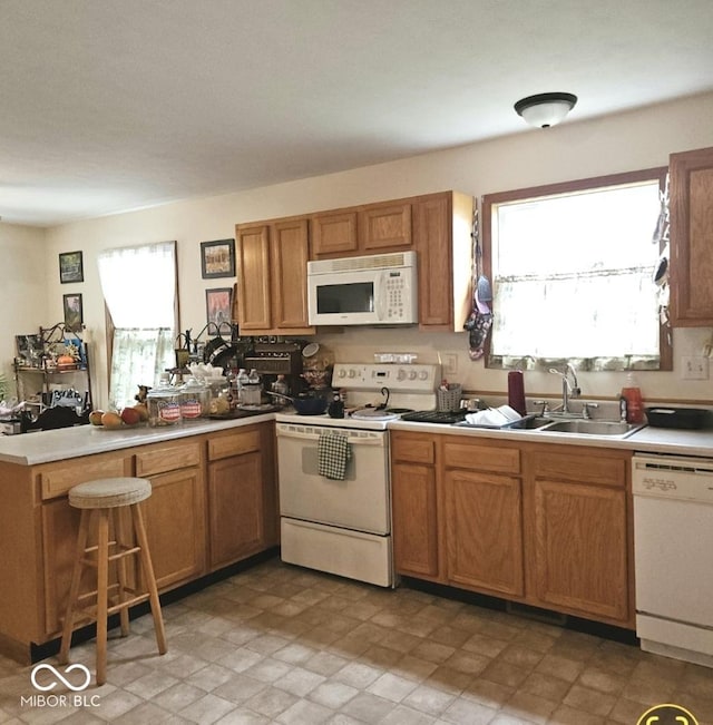 1674 W Independence St, Greensburg, IN 47240 - kitchen featuring white appliances, a peninsula, light countertops, and brown cabinetry