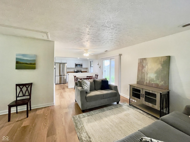 7392 S Meridian St, Indianapolis, IN 46217 - living room featuring light wood-style flooring, a ceiling fan, and a textured ceiling