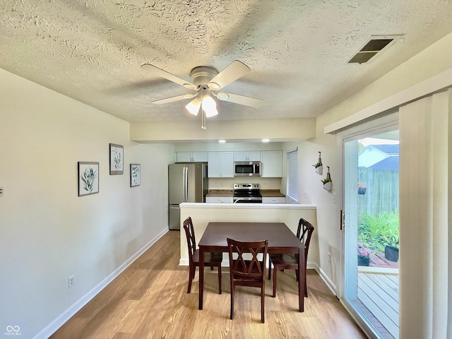 7392 S Meridian St, Indianapolis, IN 46217 - dining area with light wood-style flooring, a textured ceiling, and a ceiling fan