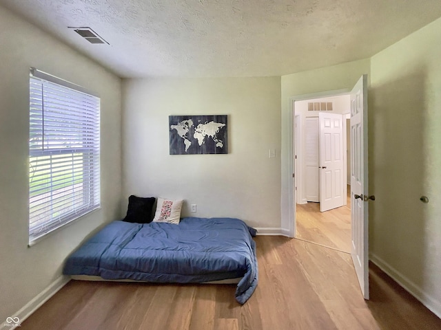 7392 S Meridian St, Indianapolis, IN 46217 - bedroom with light wood-style flooring and a textured ceiling