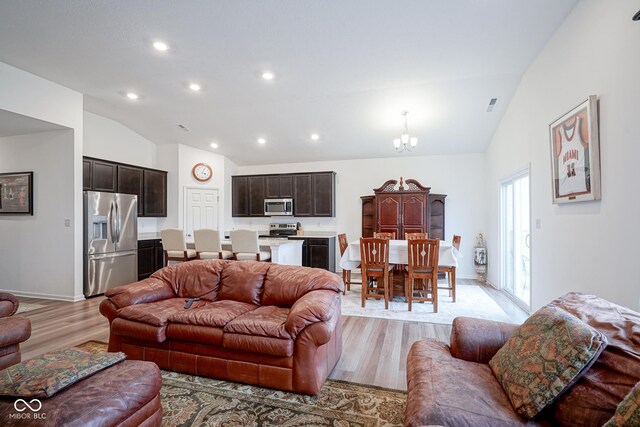 6608 W Shoreline Ct, Greenfield, IN 46140 - living room featuring vaulted ceiling, light wood-style flooring, recessed lighting, and a chandelier