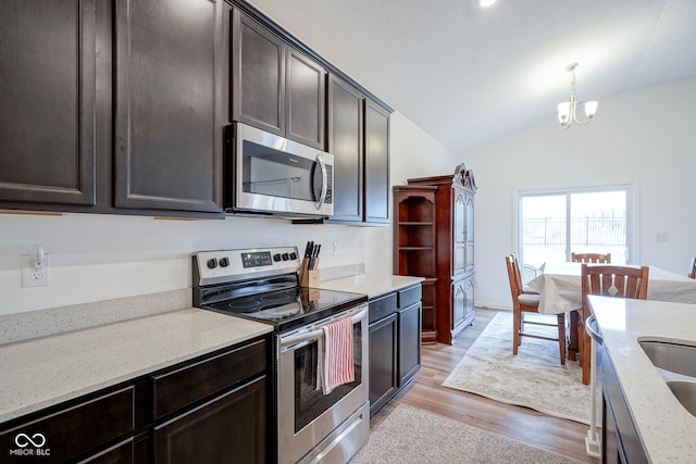 6608 W Shoreline Ct, Greenfield, IN 46140 - kitchen with stainless steel appliances, lofted ceiling, dark brown cabinetry, light wood-style floors, and a chandelier