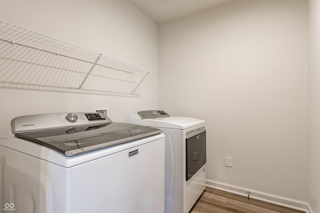 6537 Seabiscuit Rd, Whitestown, IN 46075 - washroom featuring separate washer and dryer and wood finished floors
