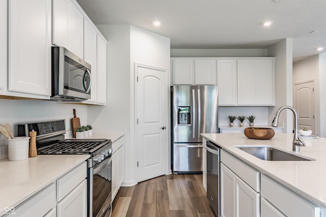 6537 Seabiscuit Rd, Whitestown, IN 46075 - kitchen featuring appliances with stainless steel finishes, wood finished floors, white cabinetry, recessed lighting, and light stone countertops