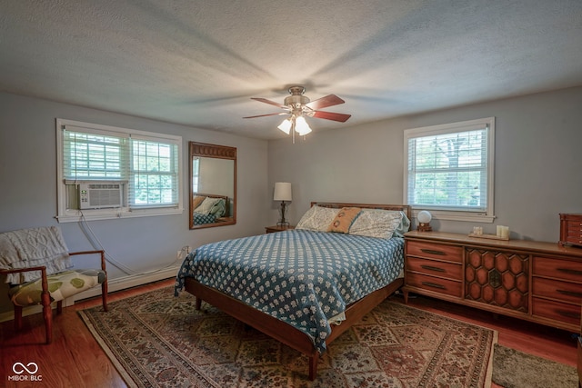1524 Northcrest Dr, Anderson, IN 46012 - bedroom with multiple windows, wood finished floors, cooling unit, a textured ceiling, and ceiling fan