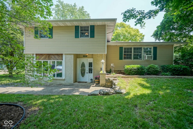 1524 Northcrest Dr, Anderson, IN 46012 - split level home featuring a front lawn, brick siding, cooling unit, and a patio