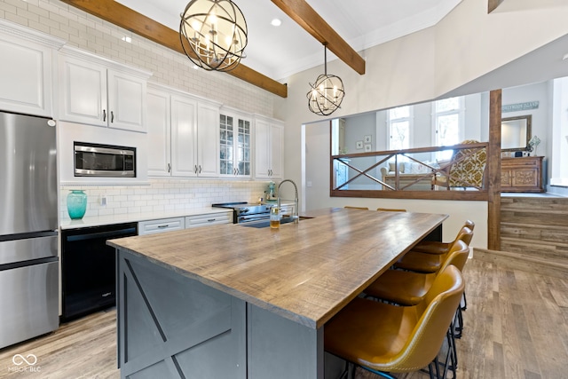 17320 Joliet Rd, Westfield, IN 46074 - kitchen with stainless steel appliances, beamed ceiling, a chandelier, light wood-style flooring, and tasteful backsplash