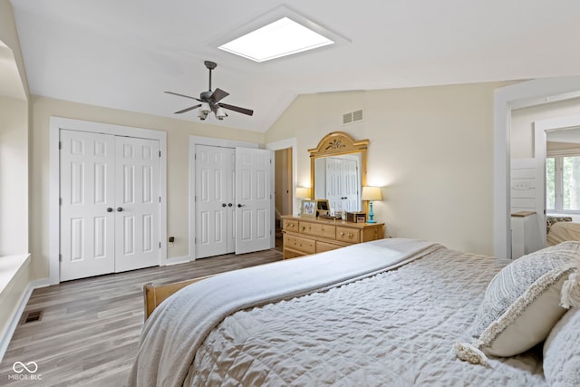 17320 Joliet Rd, Westfield, IN 46074 - bedroom with two closets, vaulted ceiling, wood finished floors, a skylight, and ceiling fan
