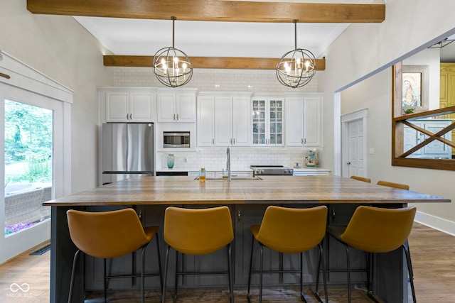 17320 Joliet Rd, Westfield, IN 46074 - kitchen with stainless steel appliances, backsplash, beamed ceiling, a chandelier, and white cabinetry