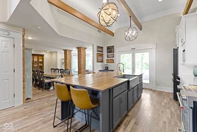 17320 Joliet Rd, Westfield, IN 46074 - kitchen featuring ornate columns, beamed ceiling, a chandelier, light wood-style floors, and french doors