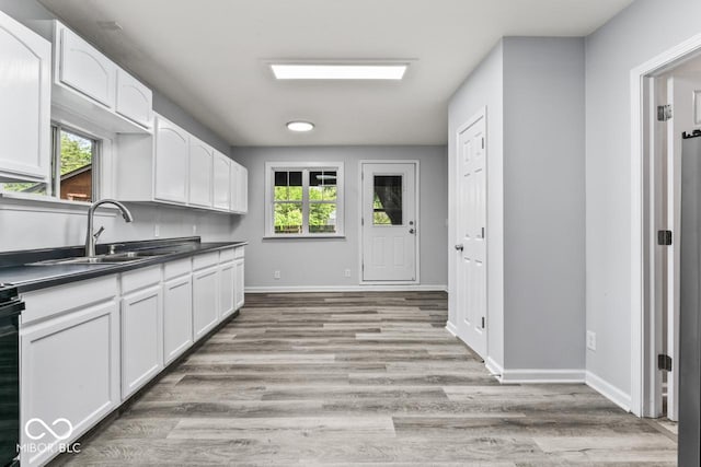 3529 Hunt St, Plainfield, IN 46168 - kitchen featuring dark countertops, white cabinets, and light wood-style flooring