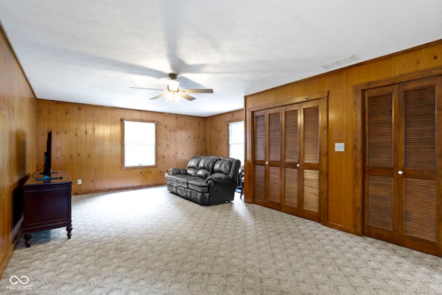 10808 Greenbriar Dr, Fishers, IN 46037 - living area with wood walls, a ceiling fan, and carpet