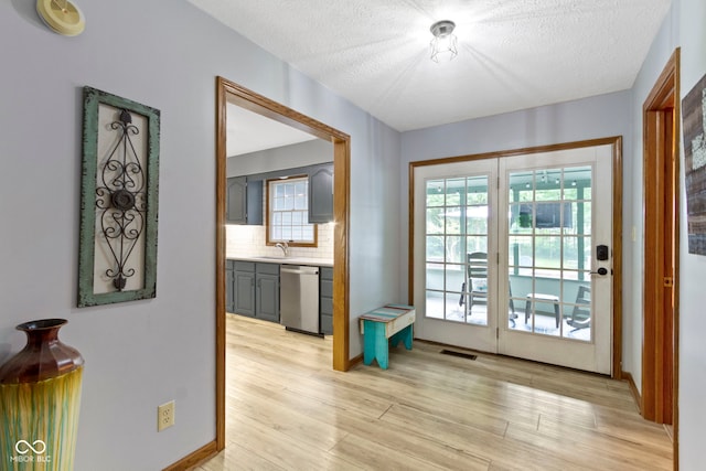 10808 Greenbriar Dr, Fishers, IN 46037 - doorway to outside featuring healthy amount of natural light, light wood-type flooring, and a textured ceiling