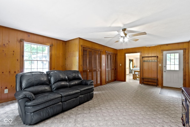 10808 Greenbriar Dr, Fishers, IN 46037 - living room with healthy amount of natural light, wood walls, a ceiling fan, and light carpet