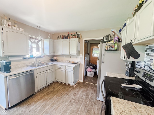 3613 N Locust St, Muncie, IN 47304 - kitchen with stainless steel appliances, light wood finished floors, light countertops, white cabinets, and decorative light fixtures