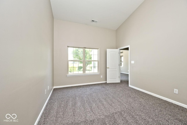 10668 Whippoorwill Ln, Indianapolis, IN 46231 - spare room with dark colored carpet and a towering ceiling