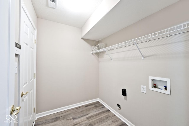 10668 Whippoorwill Ln, Indianapolis, IN 46231 - laundry room featuring washer hookup, wood finished floors, and electric dryer hookup