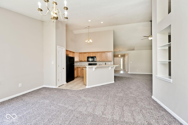 10668 Whippoorwill Ln, Indianapolis, IN 46231 - kitchen with black appliances, open floor plan, light colored carpet, light countertops, and high vaulted ceiling