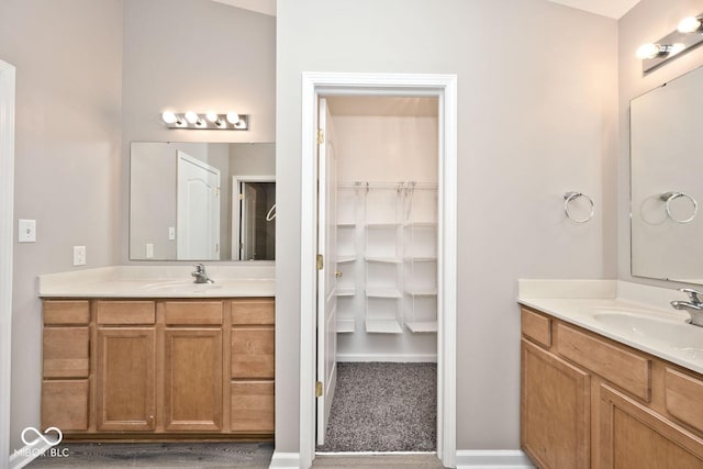 10668 Whippoorwill Ln, Indianapolis, IN 46231 - bathroom with two vanities and a spacious closet