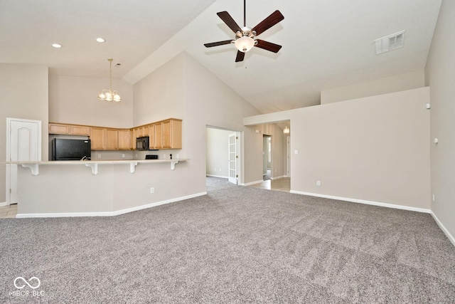 10668 Whippoorwill Ln, Indianapolis, IN 46231 - unfurnished living room with light carpet, high vaulted ceiling, a ceiling fan, and a chandelier