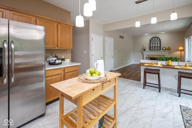 14492 Cotswold Ln, Carmel, IN 46033 - kitchen featuring freestanding refrigerator, light marble finish flooring, decorative light fixtures, and light countertops