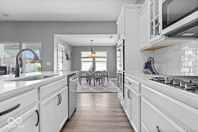4420 Wild Turkey Dr, Indianapolis, IN 46239 - kitchen featuring stainless steel appliances, a chandelier, dark wood-style floors, white cabinets, and backsplash