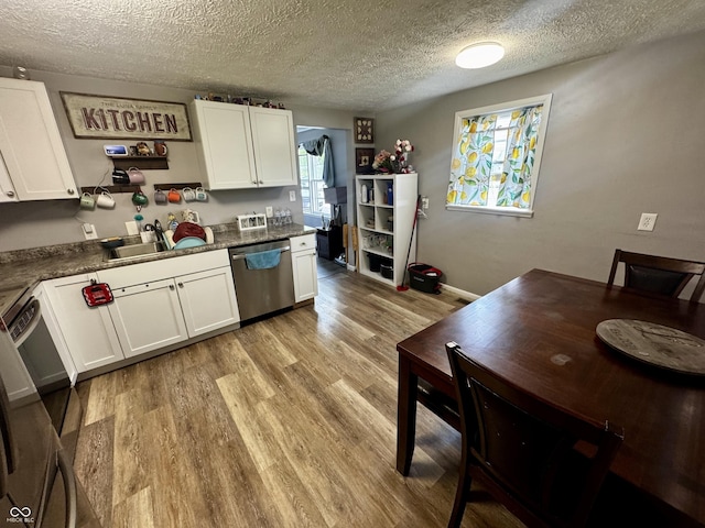 306 Waynetown Rd, Crawfordsville, IN 47933 - kitchen with stainless steel dishwasher, light wood-style floors, white cabinets, a textured ceiling, and dark countertops