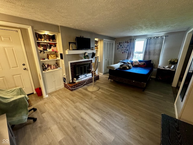 306 Waynetown Rd, Crawfordsville, IN 47933 - bedroom with a textured ceiling, wood finished floors, and a fireplace