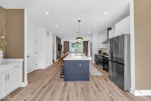 1834 Rosette Way, Indianapolis, IN 46202 - kitchen with stainless steel appliances, light wood finished floors, wall chimney range hood, white cabinets, and recessed lighting