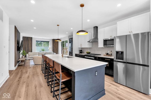 1834 Rosette Way, Indianapolis, IN 46202 - kitchen with appliances with stainless steel finishes, wall chimney exhaust hood, open floor plan, light countertops, and a kitchen bar