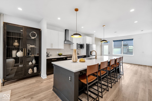 1834 Rosette Way, Indianapolis, IN 46202 - kitchen with wall chimney range hood, appliances with stainless steel finishes, a spacious island, light wood-style floors, and recessed lighting