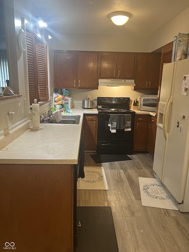 9016 Neptune Dr, Indianapolis, IN 46229 - kitchen with white fridge with ice dispenser, black / electric stove, under cabinet range hood, stainless steel microwave, and light countertops