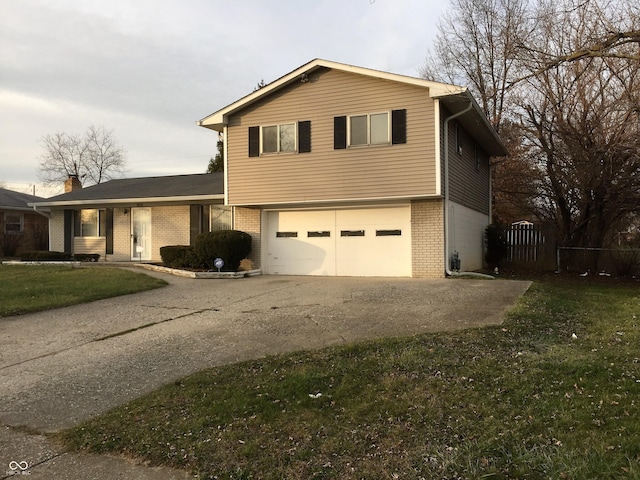 9016 Neptune Dr, Indianapolis, IN 46229 - split level home with brick siding, asphalt driveway, and a garage
