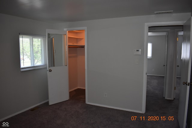 9016 Neptune Dr, Indianapolis, IN 46229 - unfurnished bedroom with a walk in closet, dark colored carpet, and a closet