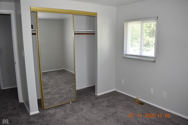 9016 Neptune Dr, Indianapolis, IN 46229 - unfurnished bedroom featuring dark carpet and a closet