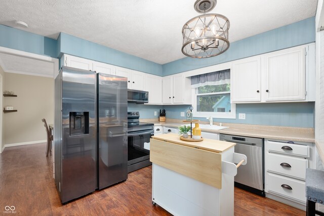 1031 Lancashire Ln, Pendleton, IN 46064 - kitchen featuring appliances with stainless steel finishes, light countertops, white cabinets, a center island, and a textured ceiling