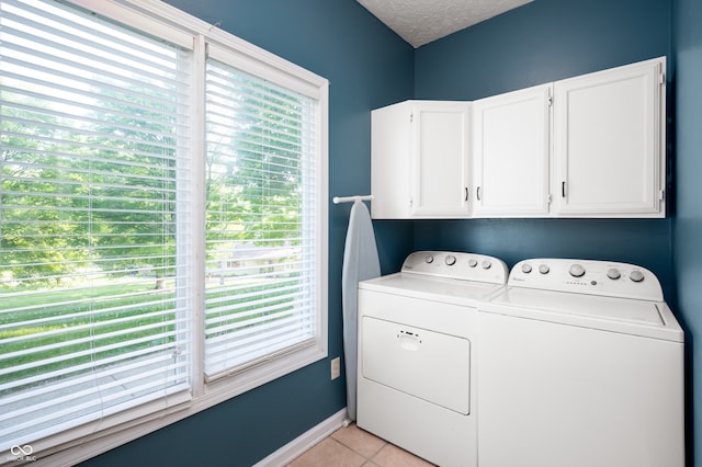 1031 Lancashire Ln, Pendleton, IN 46064 - laundry area with cabinet space, independent washer and dryer, plenty of natural light, light tile patterned flooring, and a textured ceiling