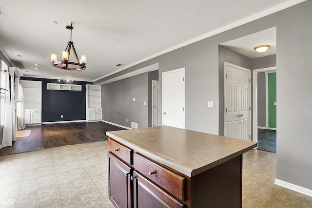 12322 Cool Winds Way W, Fishers, IN 46037 - kitchen featuring a chandelier, a kitchen island, open floor plan, hanging light fixtures, and crown molding