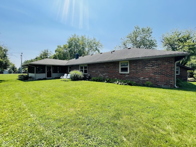 1008 Whispering Trl, Greenfield, IN 46140 - back of property featuring a yard, a sunroom, and brick siding