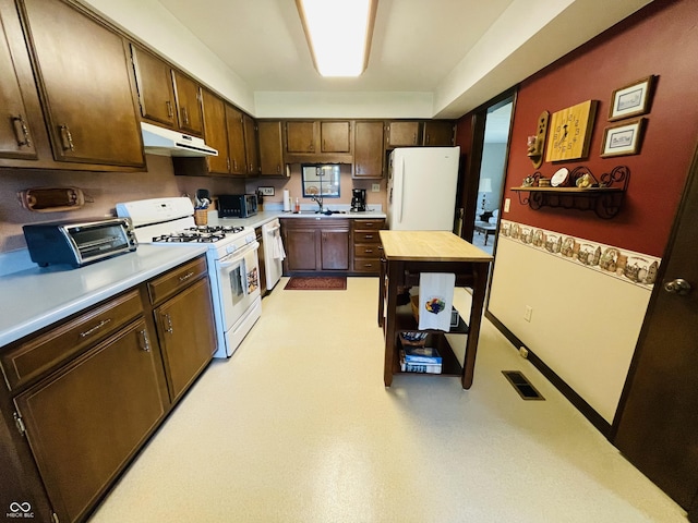 1008 Whispering Trl, Greenfield, IN 46140 - kitchen featuring white appliances, under cabinet range hood, light countertops, and dark brown cabinetry