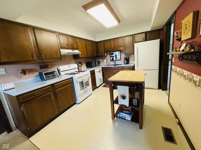 1008 Whispering Trl, Greenfield, IN 46140 - kitchen featuring white appliances, under cabinet range hood, and dark brown cabinets