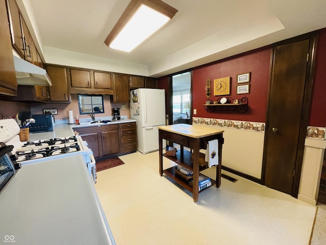 1008 Whispering Trl, Greenfield, IN 46140 - kitchen with white appliances, under cabinet range hood, light countertops, and dark brown cabinets