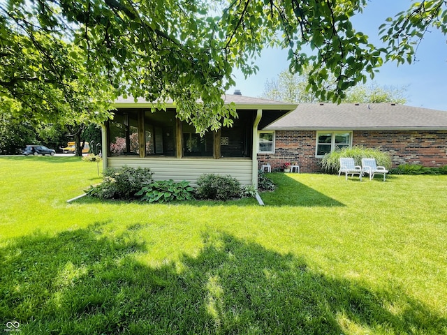 1008 Whispering Trl, Greenfield, IN 46140 - rear view of property featuring a lawn and brick siding